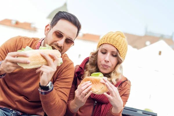 Alegre pareja romántica al aire libre disfrutando de sándwiches — Foto de Stock