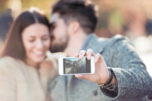 Ungt par med selfie i staden — Stockfoto