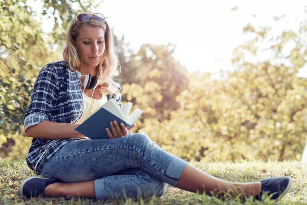 Жінка читає книгу в парку . — стокове фото