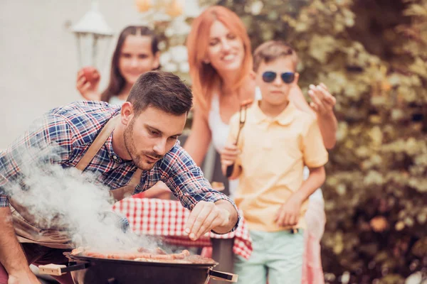 Счастливая семья с барбекю — стоковое фото