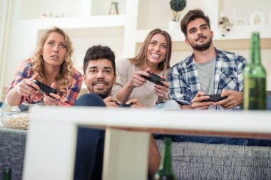 Arkadaşlar video oyun çubuğu evde oturma içinde oyun.