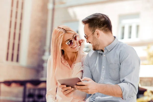 Junges Paar mit Tablet, glücklich im Freien lächelnd. — Stockfoto