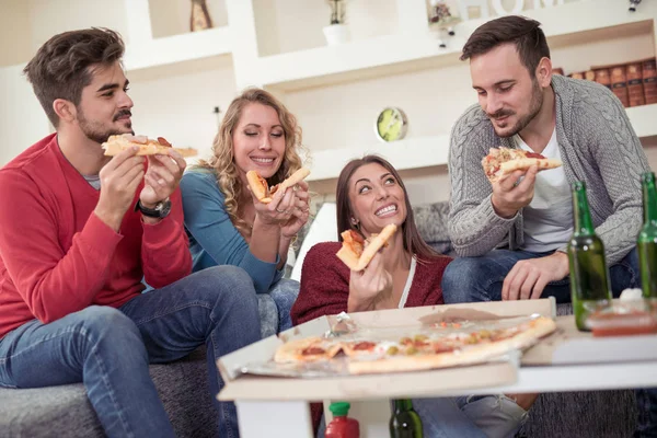 Friends with pizza and beer sitting in house