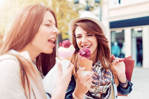 İki kız şehir sokaklarda alışveriş ile yürümek