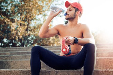 Genç adam bir şişe su içme portresi 