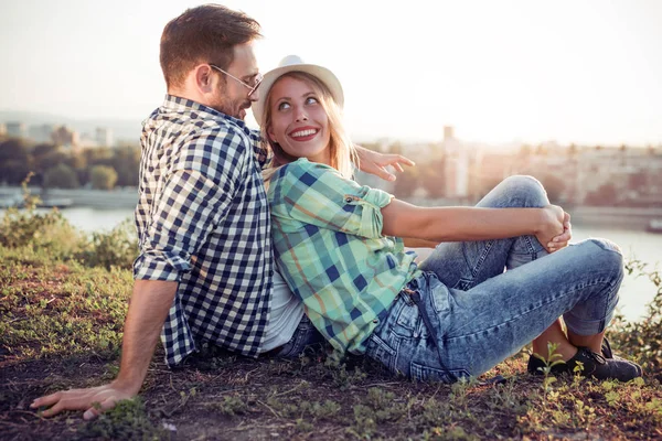Hermosa pareja joven están sentados en la hierba — Foto de Stock