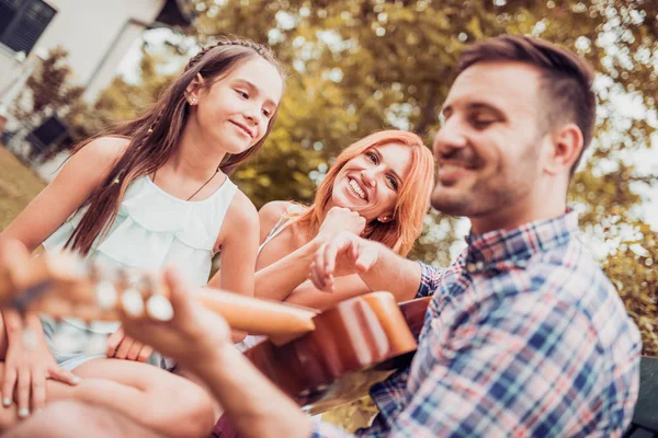 Family playing  guitar outdoors — Stock Photo, Image