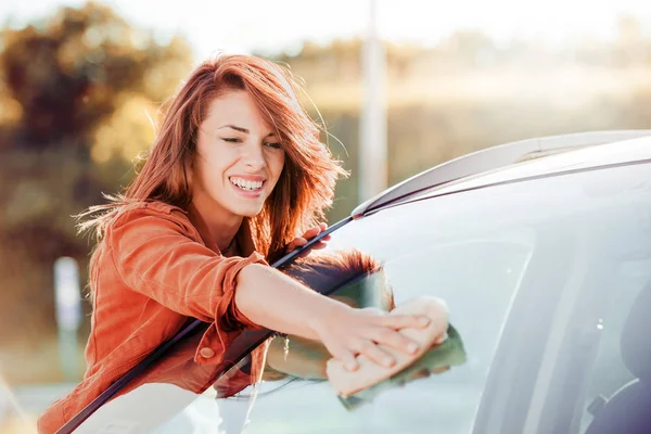 Jong meisje schoonmaak auto. — Stockfoto