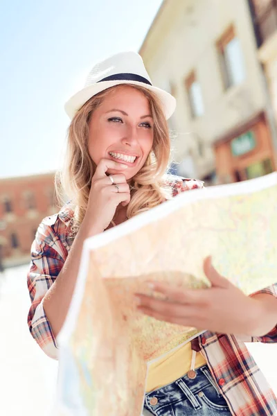 Jonge vrouw met behulp van een plattegrond van de stad — Stockfoto