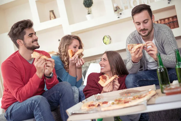 Young couples eating pizza in living room. — Stock Photo, Image