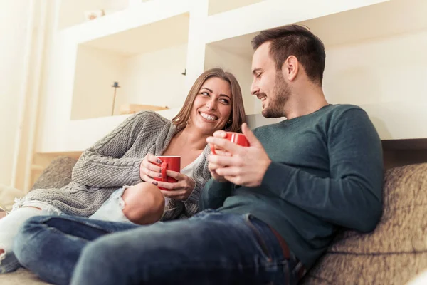 Coppia seduta sul divano e bere caffè — Foto Stock