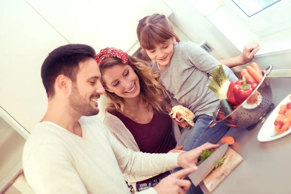 Little girl and parents cutting vegetables — Stock Photo, Image