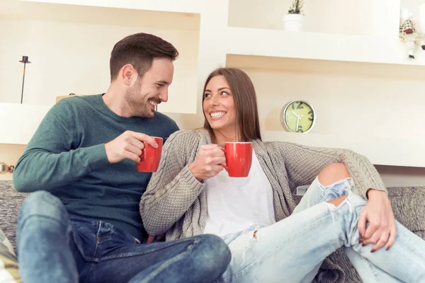 Coppia seduta sul divano e bere caffè — Foto Stock