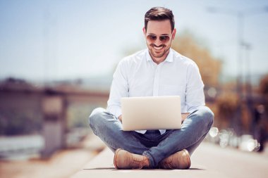 dizüstü bilgisayar kullanan yakışıklı genç