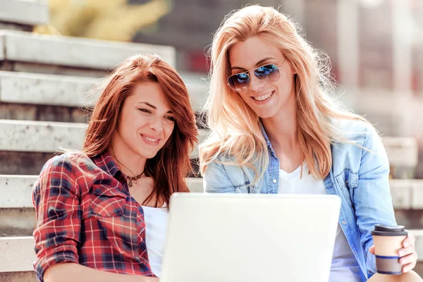 İki arkadaş medya conect satırındaki bir dizüstü bilgisayar ile izlemek.
