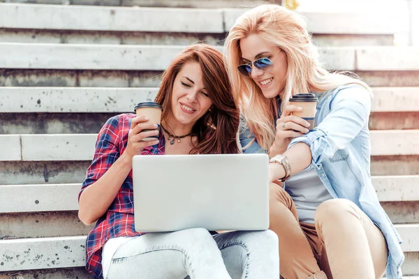Två unga kvinnan använder en laptop utomhus. — Stockfoto