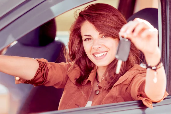 Junge fröhliche Frau hält Schlüssel für ihr erstes neues Auto in der Hand — Stockfoto