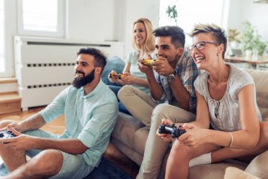 Arkadaşlar eğlenmeye video oyunları ile kanepede