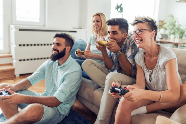 Amigos divirtiéndose en el sofá con videojuegos — Foto de Stock