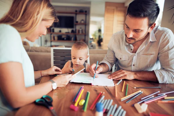 Jeune parent dessinant avec leur petit fils — Photo