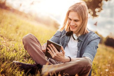Öğrenci parkta onun tablet bilgisayar kullanarak