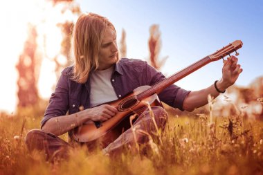 Yakışıklı genç adam gitar çalmak.