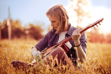 Gitar çalan genç çocuk.