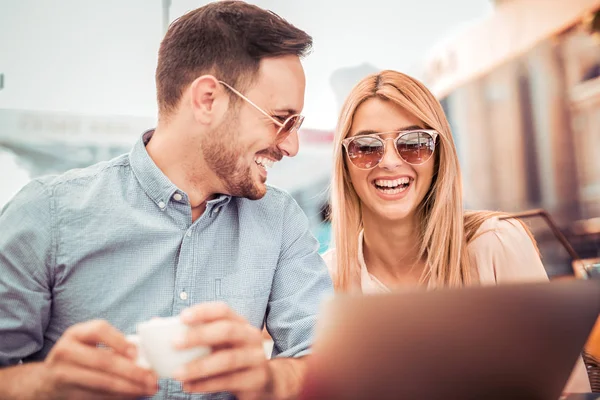 Genç çift dışarıda dizüstü bilgisayar kullanıyor.