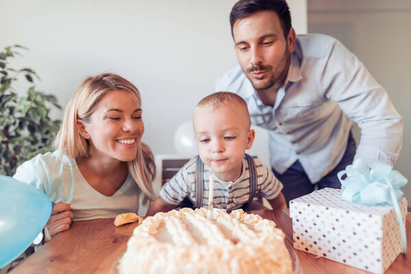 Happy family celebrating little boy's birthday at home.