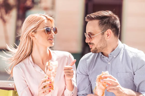 Paar genieten van lunch zit op bankje in stad. — Stockfoto