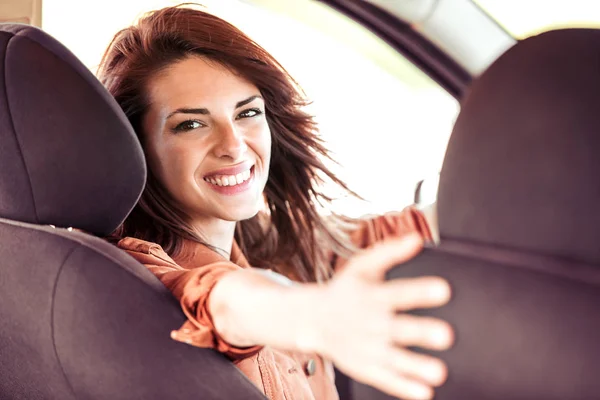 Усміхнена жінка сидить в машині — стокове фото