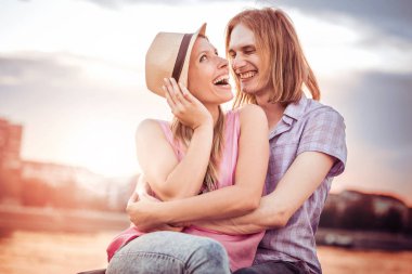 Genç çift sahilde oturuyor.