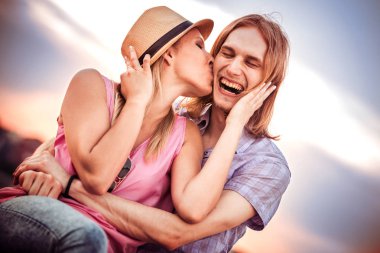 Genç çift sahilde oturuyor.