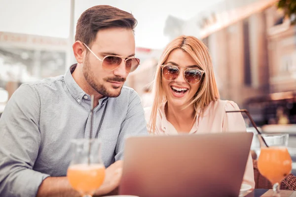 Genç çift dışarıda dizüstü bilgisayar kullanıyor. 