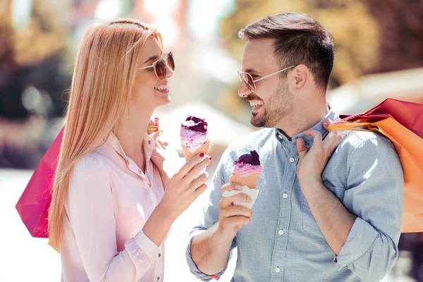 dondurma ve alışveriş torbaları ile Çift.