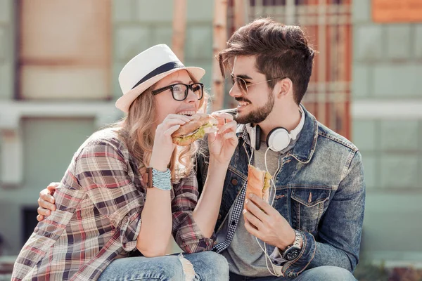 Pareja comiendo sándwich al aire libre — Foto de Stock