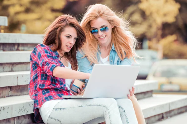 Amigos con laptop sentados en la calle . — Foto de Stock