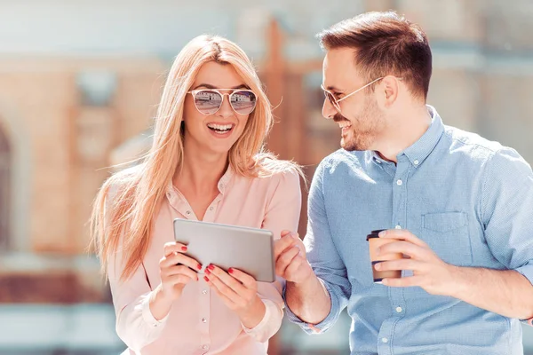 Ehepaar schaut in der Stadt auf Tablet-PC — Stockfoto