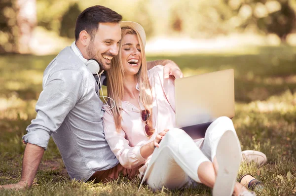 Pareja usando portátil al aire libre — Foto de Stock