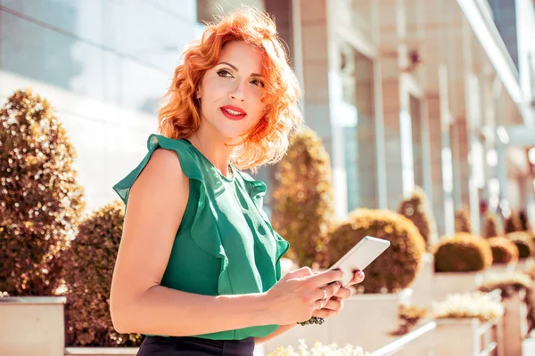 Kadın sokakta yürürken tablet ile