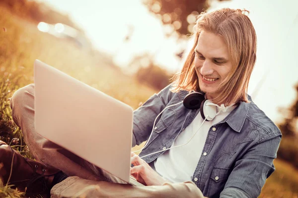 Parkta bir dizüstü bilgisayarda çalışan adam