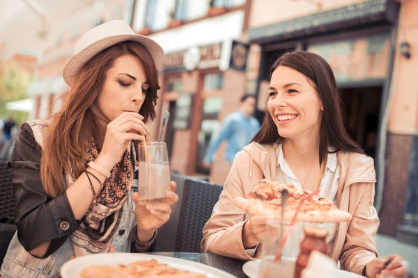 Vrouwen pizza eten in café — Stockfoto