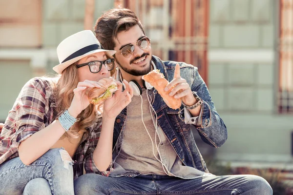 Casal comer sanduíche ao ar livre — Fotografia de Stock