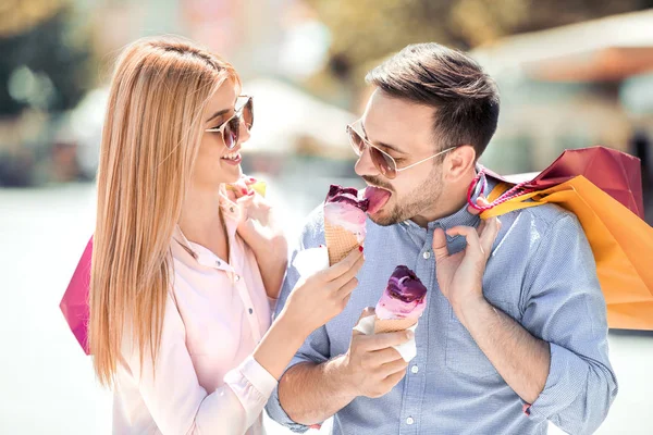 dondurma ve alışveriş torbaları ile Çift.