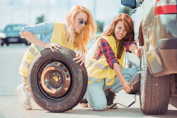 Femmes sur la route changer de pneu — Photo