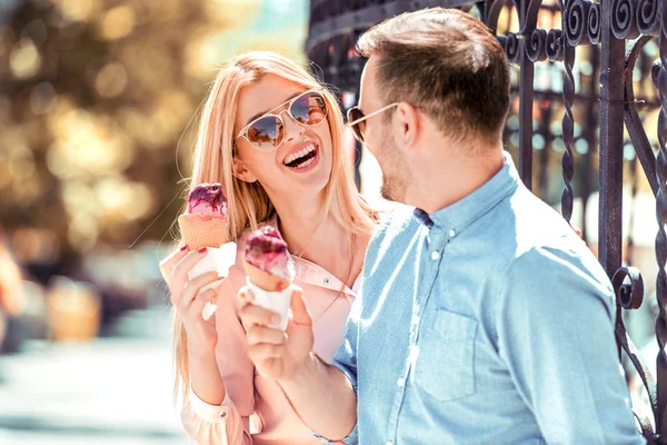 Cheerful couple eating ice cream .