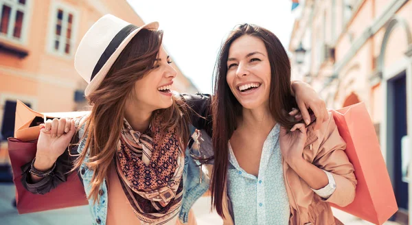 Alışveriş çantalı iki genç kadın. 