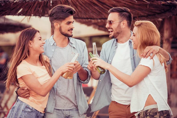 Junge Leute trinken Bier am Strand — Stockfoto