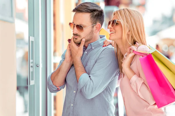 Man och kvinna som tittar i shopping fönster — Stockfoto