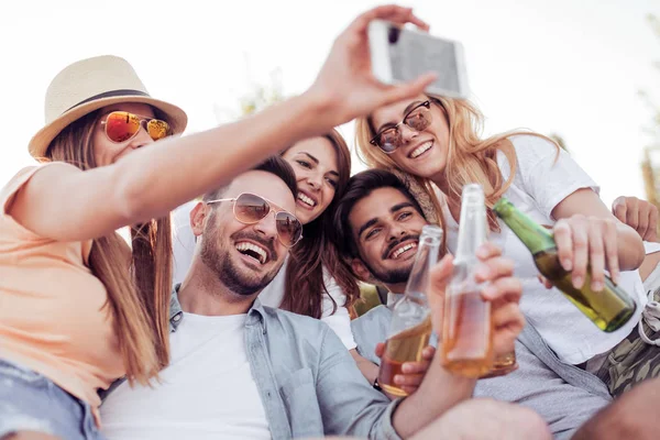 Szczęśliwi przyjaciele biorąc selfie na plaży — Zdjęcie stockowe